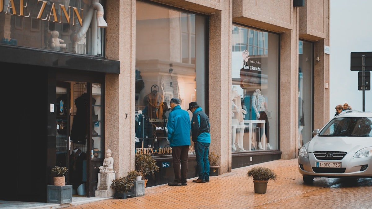 man wearing blue jacket walking on street
